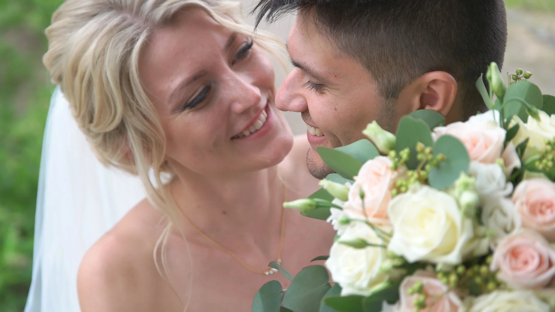 Hochzeitsfoto – romantische Nahaufnahme eines Brautpaares mit Blumenstrauß